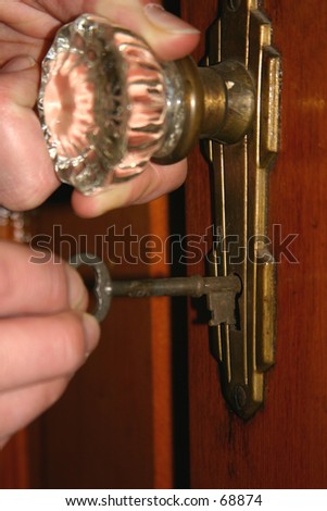 Doorknob and old-fashioned key. Shallow field of depth with focus on the end of the key/lock.