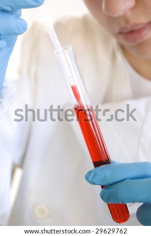 Lab Tech Taking a sample from a red test tube