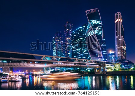 Business center with skyscrapers of Moscow-city at night under the blue sky and with reflections of the illumination on the water. Cityscape