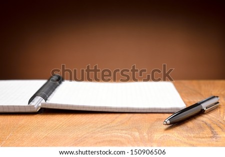 Notebook and pen on a wooden background