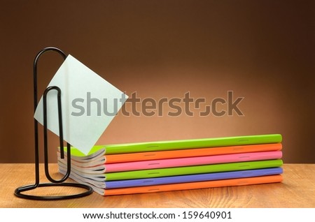 Sticker holder and notebooks on the wooden table
