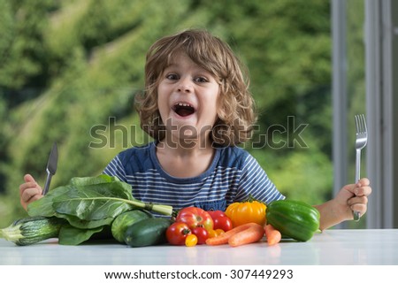 Cute little boy sitting at the table excited about vegetable meal, bad or good eating habits, nutrition and healthy eating, showing emotions concept