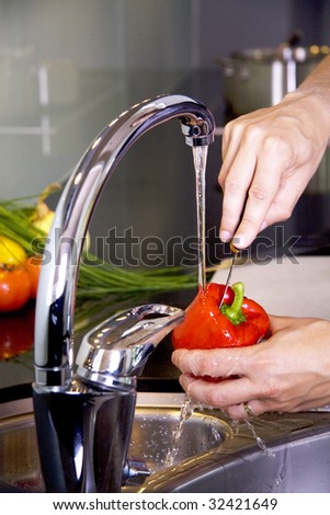 Cleansing a red pepper in the kitchen sink