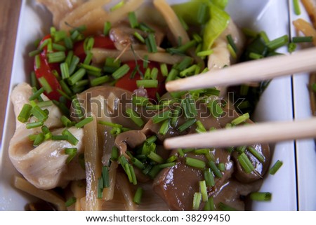 Chinese cusine with chicken and vegetable on a bambus and green background