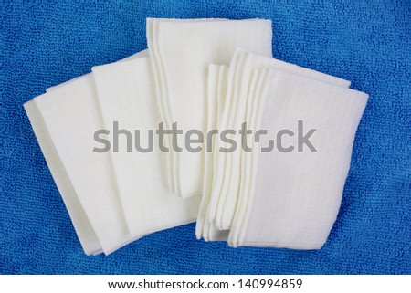 A group of prepared facial cleansing cloths on blue.