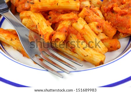 A close view of chicken pasta with marinara sauce.