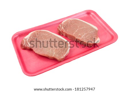 Two fresh cut pork loin steaks on a pink foam butcher tray and white background.