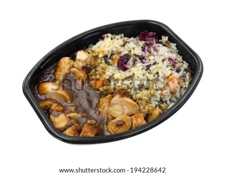A top view of a turkey with gravy and rice TV dinner in a black tray.