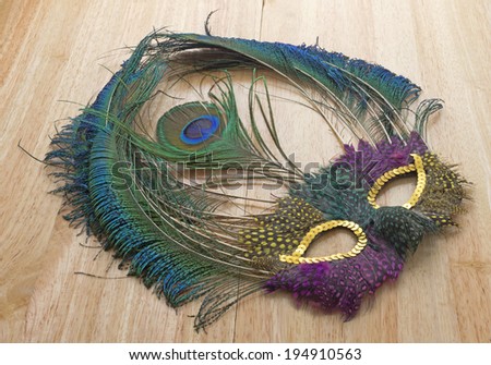 A right angle view of a vibrant old mardi gras mask on a wood grain table.