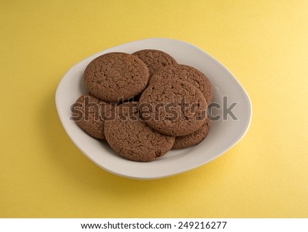 A plate filled with Dutch Cocoa soft cookies on a yellow background.