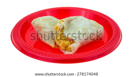 An angle view of a split breakfast burrito on a red plate.