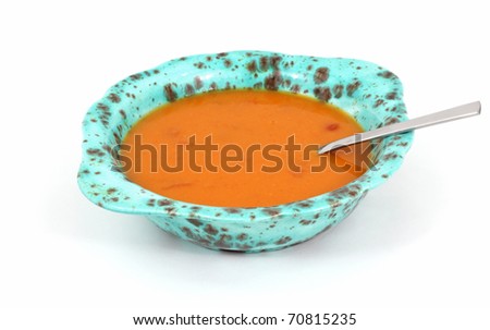 A bowl of canned tomato bisque soup and spoon.
