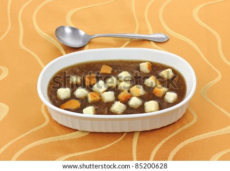 A bowl of canned french onion soup with croutons.