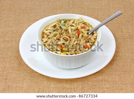 A full dish of cooked noodle and vegetable soup.