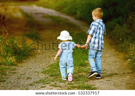 Brother and sister walk through the Park