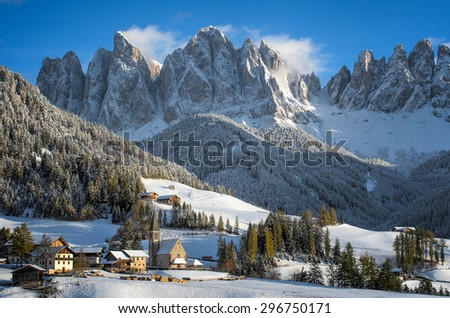 The small village of St. Magdalena or Santa Maddalena with its church covered in snow and with the Odle or Geisler Dolomites mountains in the Val di Funes Valley in South Tyrol in Italy in winter.