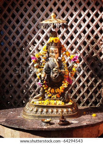 Hindu altar with candles and african marigolds for worshipping Lord Ganesh.