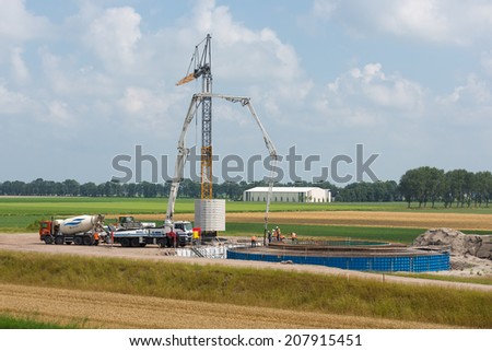 ESPEL, THE NETHERLANDS - JULY 29: Unknown workers preparing a concrete foundation of a Dutch wind turbine on July 29, 2014 at Espel, the Netherlands