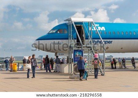 AMSTERDAM, THE NETHERLANDS - SEP 11: Viewing platform with unknown visitors and a  visitable airplane on September 11, 2014 at the airport Schiphol of Amsterdam, the Netherlands