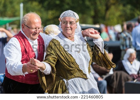 NIEUWEHORNE, THE NETHERLANDS - SEP 27: Elderly man and woman demonstrating an old Dutch folk dance during the agricultural festival Flaeijel on September 27, 2014, the Netherlands