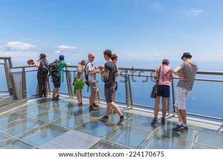 MADEIRA, PORTUGAL - AUG 04: Tourists visiting the glass observation deck at the cliffs of Gabo Girao on August 04, 2014 at Madeira Island, Portugal