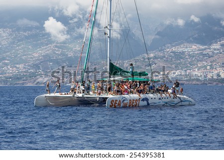 FUNCHAL, PORTUGAL - AUG 08: Tourists making a whale watching boat trip on August 08, 2014 at the ocean near Funchal, capital city of Madeira, Portugal