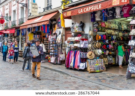 PARIS, FRANCE - May 28: Tourists and street artists walking near the gift shops of Montmartre, close to the famous Sacre Coeur Basilica on May 28, 2015, Paris, France