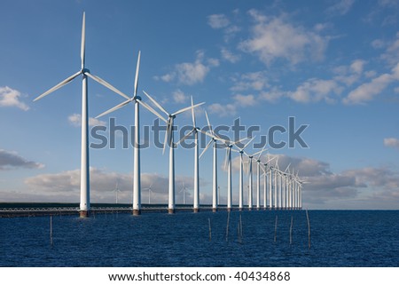 Enormous windmills standing in the sea along a Dutch sea barrier