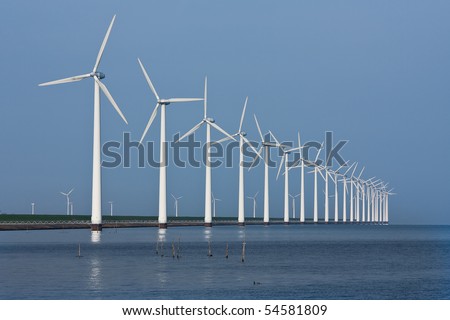 Long row of wind turbines, mirrored in the Dutch sea