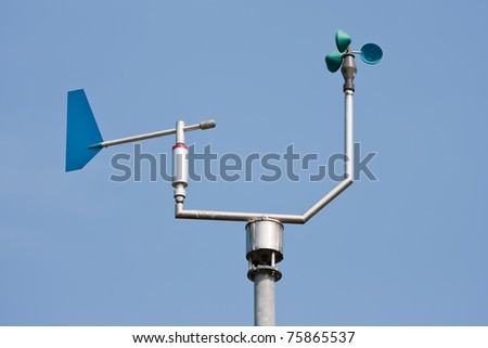 Anemometer measuring wind speed and direction with a blue sky in the background