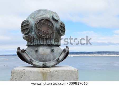 An old deep sea diving helmet, near Cannery Row in Monterey, California (USA) commemorates the divers and who installed and maintained underwater sardine pipes and pumps, including 2 who died.