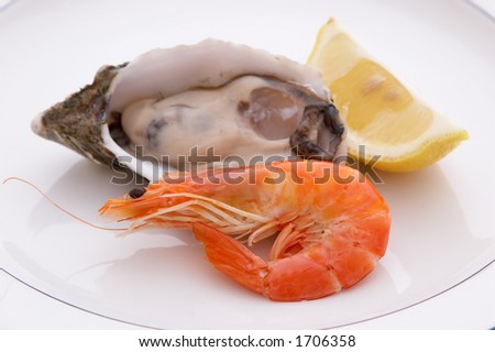 Oyster in the shell with a prawn and a lemon on a plate