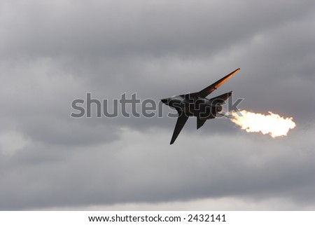 Front line jet fighter in the air doing a fuel dump and flame