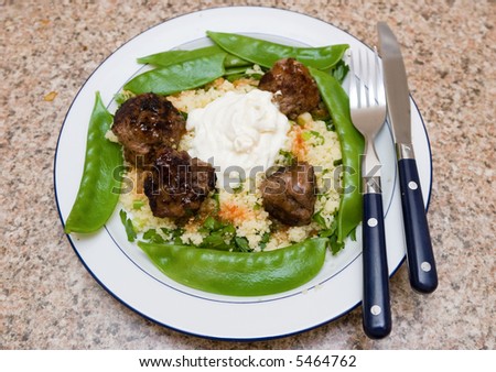Meal consisting of meatballs, couscous, snow peas and yogurt
