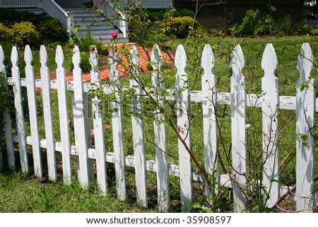 a white fence around a front yard