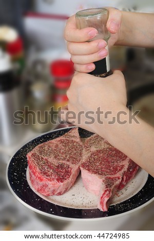 grounding black pepper on the steak