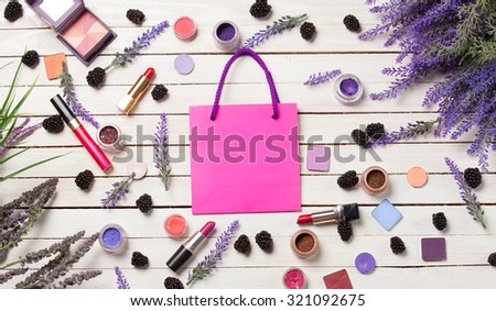 Pink bag and cosmetics on white wooden background