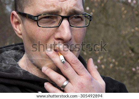 adult man with glasses smoking cigarette