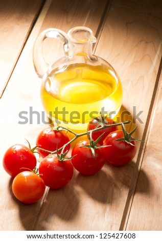 olive oil with tomatoes on wooden table olive oil with tomatoes on wooden table