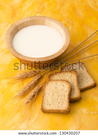 Cup of milk with wheat and slices of bread