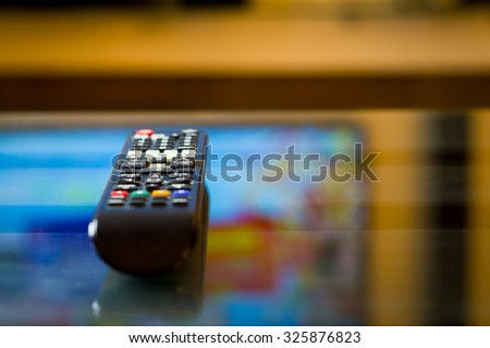 TV (television) remote on the glass table (color toned image)