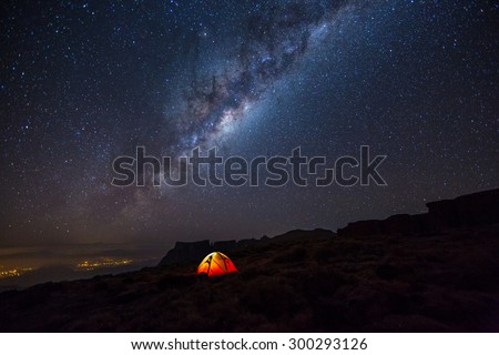 Camping under the stars. The Milky Way stretches overhead the tent high above the villages in the Drakensberg mountains, on the Amphitheatre.