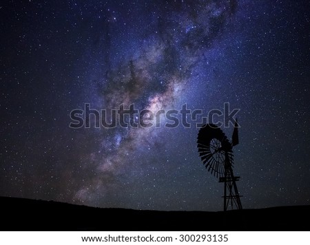 The milky way core rises above a windmill in the Karoo desert, South Africa.