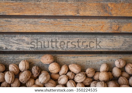 Walnuts\
Many walnuts in a vintage wooden background. Autumn composition.