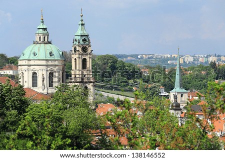 View on the spring Prague St. Nicholas\' Cathedral with the green Nature and flowering Trees, Czech Republic