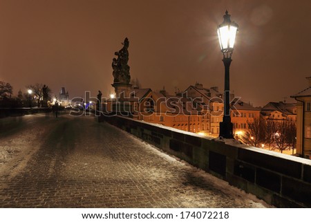 Night romantic snowy Prague Old Town above River Vltava from Charles Bridge, Czech republic