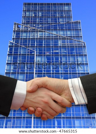 Businessmen shaking hands in front the Skyscraper on the blue Sky