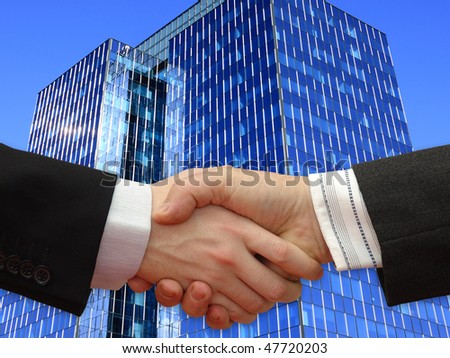 Businessmen shaking hands in front the Skyscraper on the blue Sky