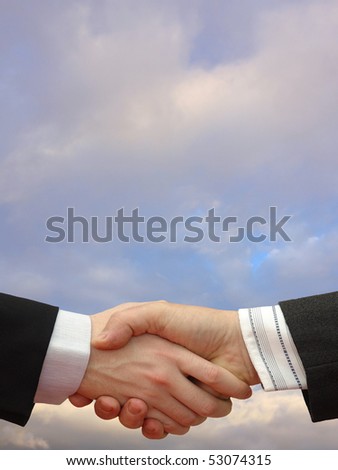 Businessmen shaking hands on the cloudy Sky