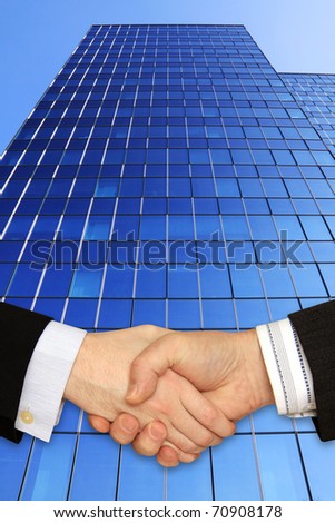 Businessmen shaking hands in front of the Skyscraper